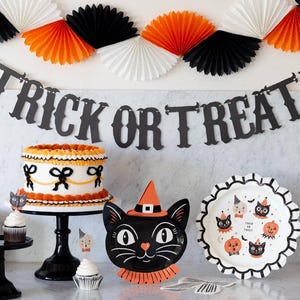 Halloween-themed table setting with cake, decorations, and showing the 6ft 'Trick or Treat' banner.