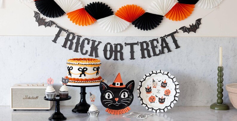 Halloween-themed table setting with cake, decorations, and showing the 6ft 'Trick or Treat' banner.