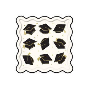 May include: A square, scalloped-edge plate with a cream-colored background. The plate is decorated with black graduation caps with gold tassels and small gold stars. The border is black.