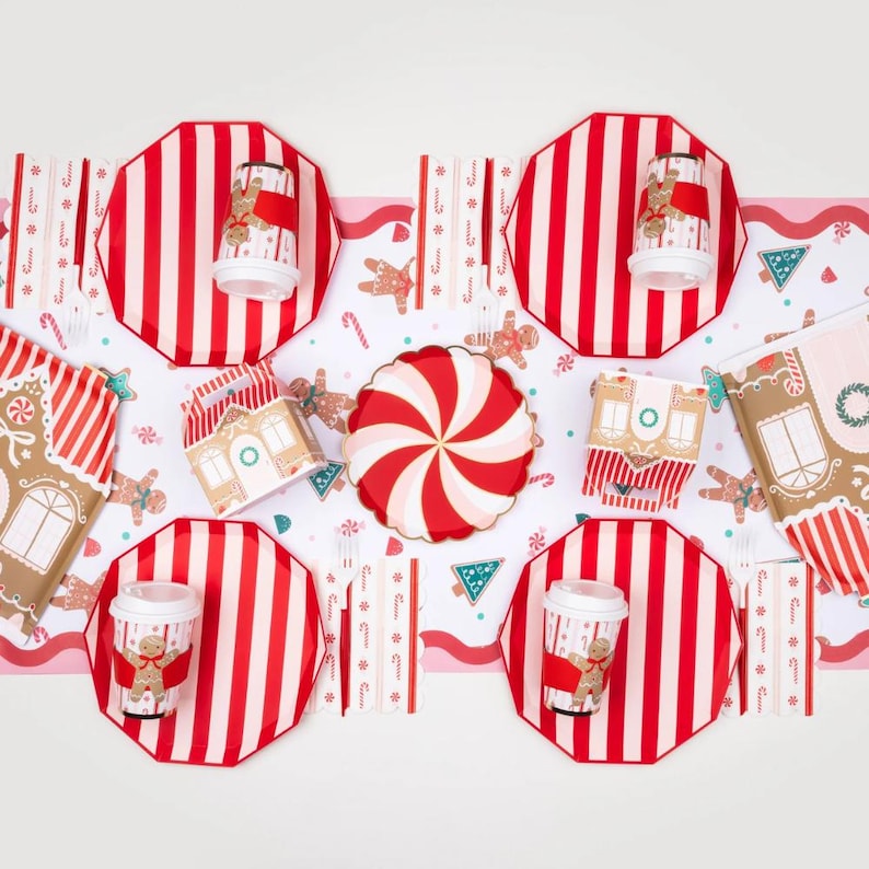 Gingerbread-themed holiday table setup with striped plates and candy décor.