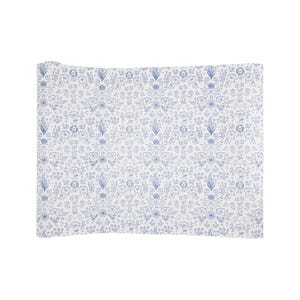 May include: White wrapping paper with a blue floral pattern. The pattern features small flowers, leaves, and stems.