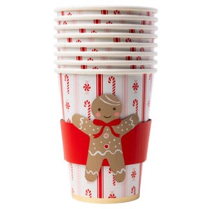 Stack of candy cane–striped paper cups with gingerbread man sleeves.