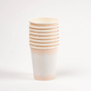 May include: A stack of white paper cups with a light orange dotted pattern around the rim.