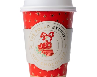 May include: A red disposable hot beverage cup with a white lid, featuring a gold star pattern and a central white sleeve. The sleeve displays a red steam train graphic, a red bow, and the text The Polar Express Hot Chocolate.