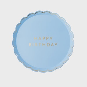 May include: A light blue, scalloped-edge paper plate with gold lettering that reads "HAPPY BIRTHDAY". The plate is round and has a gold trim around the edge.