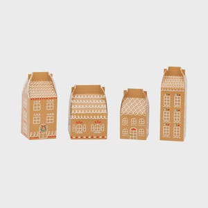 May include: Four cardboard gingerbread house-shaped boxes. The boxes are tan with white icing details, including windows, doors, and roof decorations. Each house has a unique design, with red and green accents.