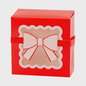 May include: A red gift box with a white bow design. The box has a scalloped window revealing the bow. A red band wraps around the box. The bow has red outlines and a square center.