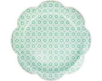 May include: A green paper party plate with a white floral pattern. The plate has a scalloped edge.