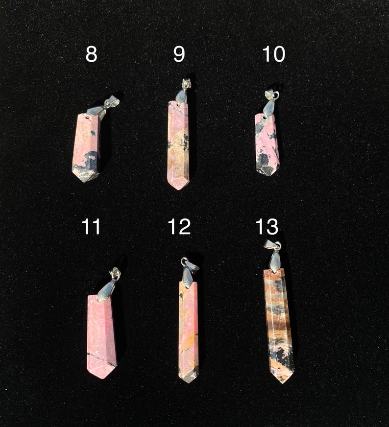 May include: Six pink and black gemstone pendants with silver bail. The pendants are numbered 8 through 13.