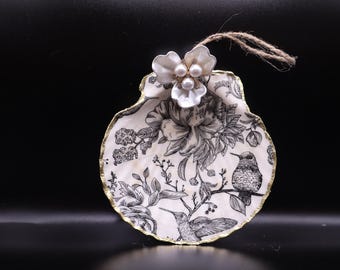 Colibrí blanco y negro con flor de metal