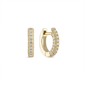 May include: A pair of gold hoop earrings with a row of small diamonds around the edge.