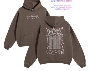 May include: A dark brown hooded sweatshirt featuring a front graphic with the text Olivia Rodrigo surrounded by small pink flowers. The back displays the text The Unraveled Tour Olivia Rodrigo with a list of tour dates and pink flowers.