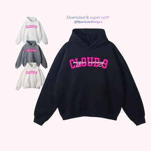 K&ouml;nnte beinhalten: Ein schwarzer Kapuzenpullover mit einem rosa "CLOUD 9"-Schriftzug und dem Namen "megan moroney" in Schreibschrift. Drei weitere Kapuzenpullover in Wei&szlig; und Grau sind abgebildet. Der Text "Oversized & super soft! @OpenLateDesigns" ist ebenfalls sichtbar.