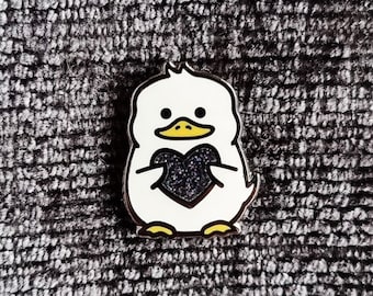 Weiße Ente Emaille Pin mit schwarzem Glitzerherz (Jaspis)