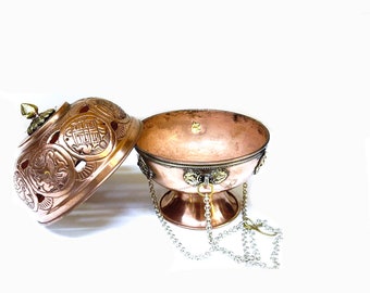May include: A copper incense burner with a lid and a chain. The burner has intricate designs and is decorated with gold accents.