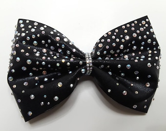 May include: A black bow with iridescent rhinestones and a silver band in the center.