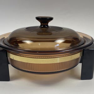 Cocotte ronde ambrée/couverte brune avec berceau pour servir - Ustensiles de cuisine sur la cuisinière/la cuisinière