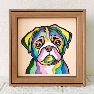 May include: A colorful paper cut-out of a pug dog in a wooden frame. The dog is made of layered paper in shades of pink, blue, green, and yellow.