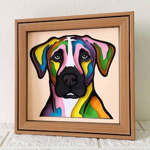 May include: A colorful paper art portrait of a dog with a white muzzle and black nose. The dog's fur is layered with shades of yellow, green, pink, blue, and purple. The portrait is framed in a natural wood frame.