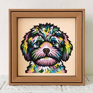 Peut inclure: Un portrait de chien en papier découpé coloré dans un cadre en bois. Le chien a un visage blanc avec une fourrure rose, verte, bleue et jaune.