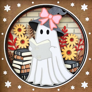 Op de afbeelding: Een witte geest met een grijze heksenhoed met een roze strik leest een boek. De geest wordt omringd door bloemen en een stapel boeken. De achtergrond is een bruine bakstenen muur.