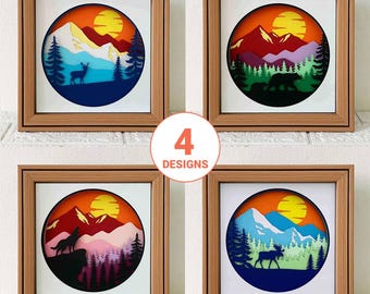 May include: Four framed paper cut-out designs featuring a mountain scene with a sun, trees, and animals. The designs include a deer, a bear, a wolf, and a moose.