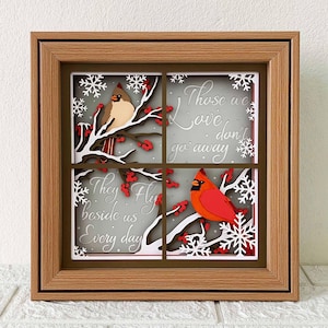 May include: A wooden framed shadow box with a winter scene featuring two red cardinals, snowflakes, and the text "Those we love don't go away, they fly beside us every day."