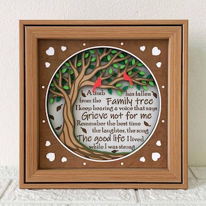 Puede incluir: Una pieza de arte de pared enmarcada en madera con un diseño de árbol cortado con láser con pájaros rojos. El texto dice "A limb has fallen from the Family tree I keep hearing a voice that says Grieve not for me Remember the best time the laughter, the song The good life I lived while I was strong".
