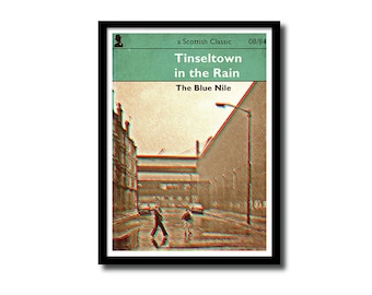 May include: A vintage book cover with a green background and the title "Tinseltown in the Rain" by The Blue Nile. The cover features a black and white photo of a street scene with two people walking in the rain.