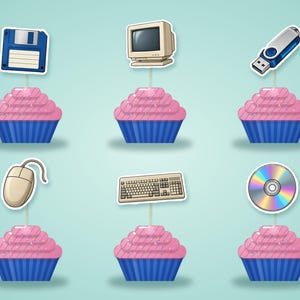 May include: Six cupcakes with pink frosting and blue liners, each topped with a computer-themed paper cutout: a blue floppy disk, a beige monitor, a blue USB drive, a beige computer mouse, a beige keyboard, and a circular iridescent disc.