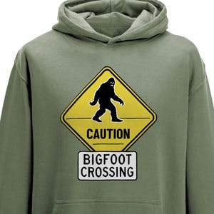 Bigfoot Crossing Hoodie, Zabawna bluza Sasquatch, Bluza z kapturem Cryptid Unisex, Prezent dla Miłośnika Bigfoot, Koszulka Caution Bigfoot, Przygoda na świeżym powietrzu