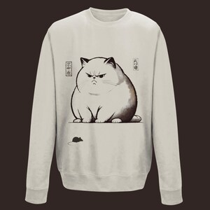 Peut inclure: Un sweat-shirt gris clair avec une illustration en noir et blanc d'un chat grognon avec le texte japonais "大福猫" et "三福猫" sur le devant. Une petite souris noire se trouve sous le chat.