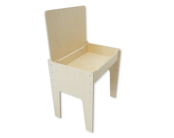 Può includere: Una scrivania e una sedia per bambini in legno chiaro con un piano a cerniera che si apre per rivelare un vano portaoggetti.