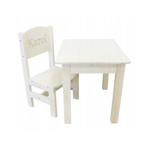 Può includere: Un set di tavolo e sedia in legno bianco per bambini. La sedia ha il nome "Karol" inciso sullo schienale.