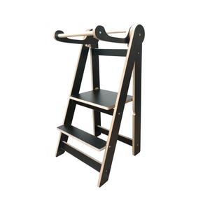 Peut inclure: Un tabouret d'escalier en bois noir avec une barre de sécurité intégrée. Le tabouret a deux marches et une plateforme en haut. Le tabouret est en contreplaqué et a une finition en bois naturel.