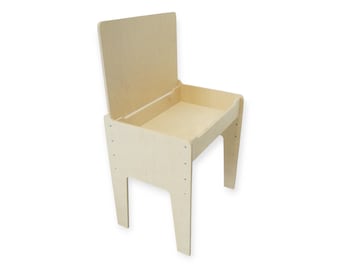 Può includere: Una scrivania in legno chiaro con un piano incernierato e un'area di stoccaggio. La scrivania ha quattro gambe ed è progettata per i bambini. La scrivania è realizzata in legno non rifinito e ha un design semplice e minimalista.