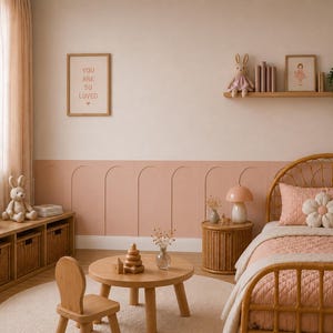 K&ouml;nnte beinhalten: Ein Kinderzimmer mit einem Rattanbett, einer rosafarbenen Steppdecke und einem blumenf&ouml;rmigen Kissen, einem runden Holztisch mit einem Stapelspielzeug, einem Holzstuhl, einem niedrigen Regal mit Weidenk&ouml;rben und einem Wandregal mit Pl&uuml;schhase.