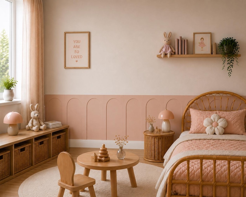 K&ouml;nnte beinhalten: Ein Kinderzimmer mit einem Rattanbett, einer rosafarbenen Steppdecke und einem blumenf&ouml;rmigen Kissen, einem runden Holztisch mit einem Stapelspielzeug, einem Holzstuhl, einem niedrigen Regal mit Weidenk&ouml;rben und einem Wandregal mit Pl&uuml;schhase.