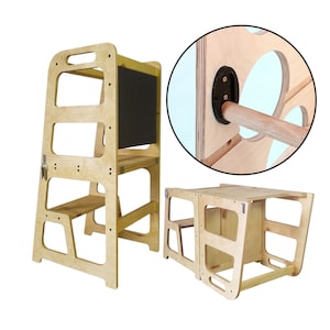 May include: A wooden learning tower with a chalkboard and a small step stool. The tower is designed to help children reach worktops and participate in kitchen activities. The tower is made of natural wood and has a simple, modern design.