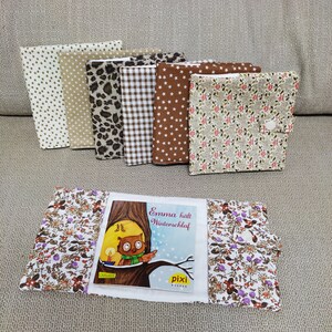 Könnte beinhalten: Ein Satz von acht Buchumschlägen aus Stoff mit verschiedenen Mustern. Die Umschläge sind in verschiedenen Farben, darunter Braun, Beige, Weiß und Schwarz. Die Umschläge sind in einer Reihe angeordnet, wobei die Buchumschläge auf der linken Seite des Bildes die Buchumschläge auf der rechten Seite des Bildes leicht überlappen. Die Buchumschläge sind alle gleich groß und gleich geformt. Die Buchumschläge sind alle aus einem weichen, strukturierten Stoff gefertigt. Die Buchumschläge sind alle mit verschiedenen Mustern verziert. Die Buchumschläge sind alle in gutem Zustand. Die Buchumschläge sind alle gebrauchsfertig. Die Buchumschläge sind alle bereit, genossen zu werden. Die Buchumschläge sind alle bereit, geliebt zu werden.