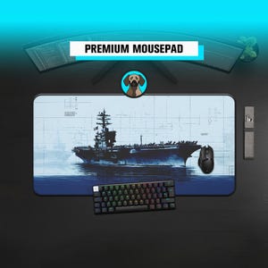 May include: A rectangular mousepad featuring a navy blue and white warship illustration. A black keyboard and mouse are positioned on the pad. The text "PREMIUM MOUSEPAD" is displayed above the mousepad.