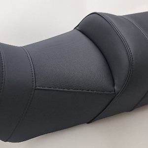 Op de afbeelding: Zwarte motorfietszadel met een gestructureerd oppervlak en een gestikt ontwerp.