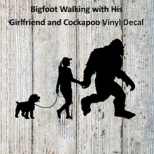 May include: Black vinyl decal featuring a silhouette of Bigfoot holding hands with a person, walking a Cockapoo dog on a leash. The text "Bigfoot Walking with His Girlfriend and Cockapoo Vinyl Decal" is at the top.