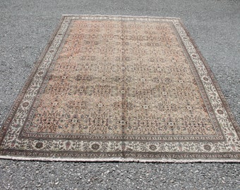 May include: A vintage rug with a beige background and a floral pattern in shades of brown, pink, and cream. The rug has a border with a repeating design.