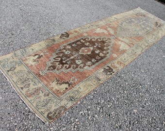 May include: A vintage runner rug with a traditional Persian design. The rug has a red, brown, and beige color scheme with intricate floral and geometric patterns.