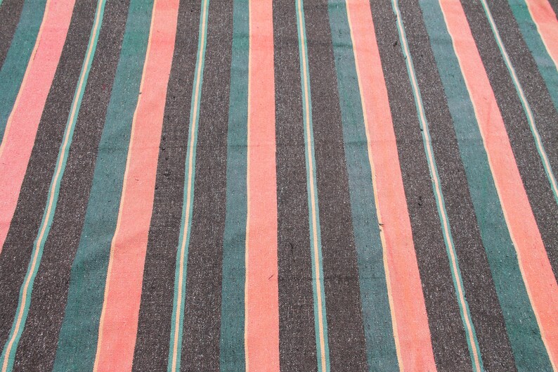 May include: Striped fabric with alternating bands of black, teal, and pink. The fabric has a woven texture.