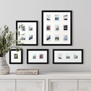 Könnte beinhalten: Ein Satz von fünf schwarzen Bilderrahmen mit weißen Passepartouts, die jeweils eine andere Anordnung von kleinen Fotos zeigen. Die Rahmen sind versetzt an einer weißen Wand angeordnet.