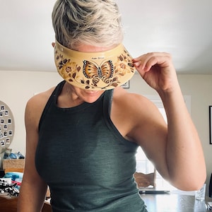 May include: A yellow visor with a butterfly design and the text "Palm Springs" on it.