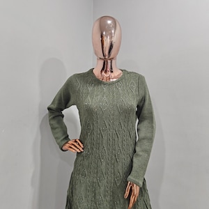 May include: A long-sleeved, green knitted dress with a diamond pattern and sparkly embellishments.