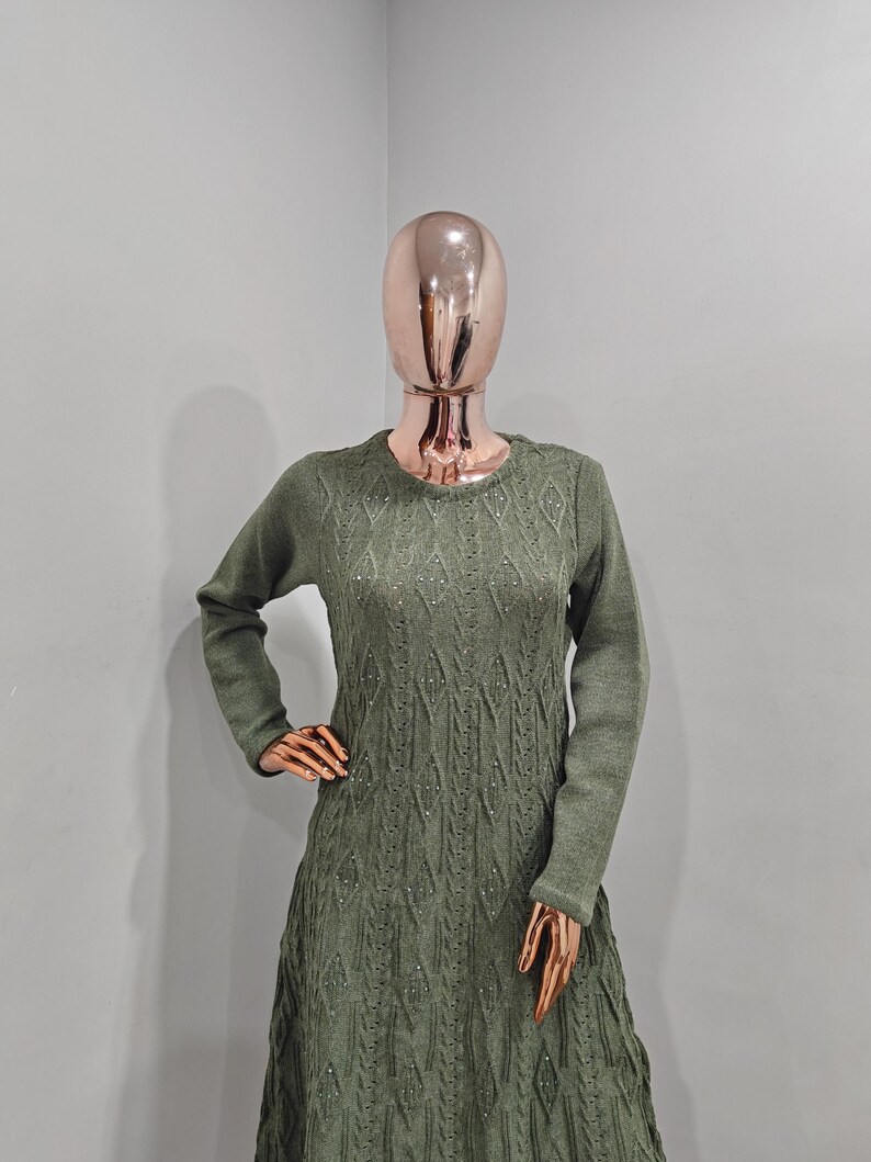 May include: A long-sleeved, green knitted dress with a diamond pattern and sparkly embellishments.